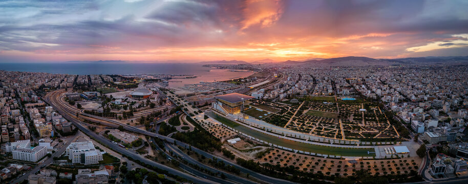 Wide aerial panorama of the Faliro Delta and Kallithea district until Piraeus in south Athens, Greece, with yacht marinas and road infrastructure during a colorful sunset