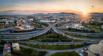 Aerial panoramic view of multilevel highway intersection road as seen in Attiki Odos toll road motorway, Athens, Greece, during golden sunset time