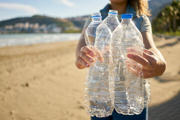 Activist holding empty plastic bottles at beach