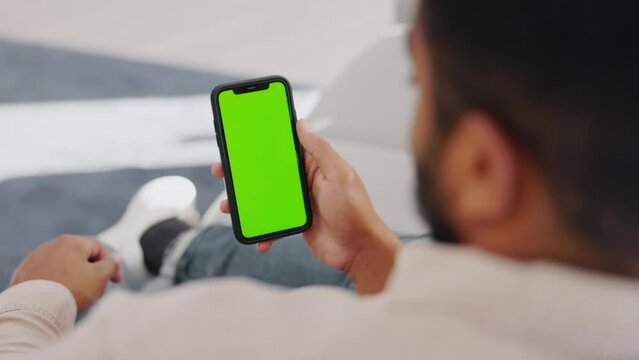 Man, cellphone screen and green mockup on sofa to relax on social media, online user and watching subscription. Guy, smartphone and blank mock up on mobile app, download games, and digital connection