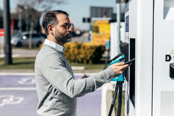 Man paying through smart phone at car charging station