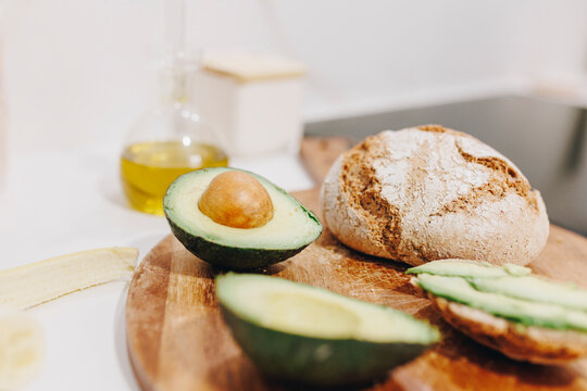 Sliced avocado and bread on cutting board
