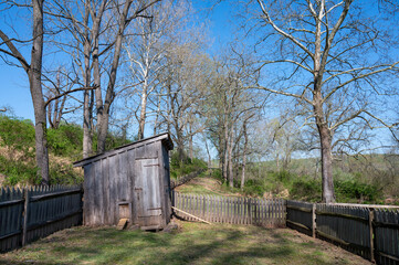 Fototapeta na wymiar Rustic free range chicken coop with fence in idyllic farm with country dirt road and wooden fence. Sunshine, no people, with copy space.