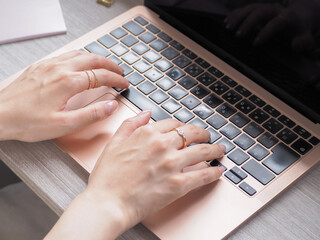 ノートPCとタイピングする女性の手