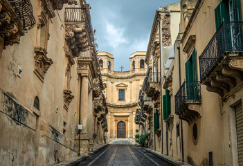 Fototapeta na wymiar Street in historic part of Noto city, Sicily in Italy, view with Montevergine Church