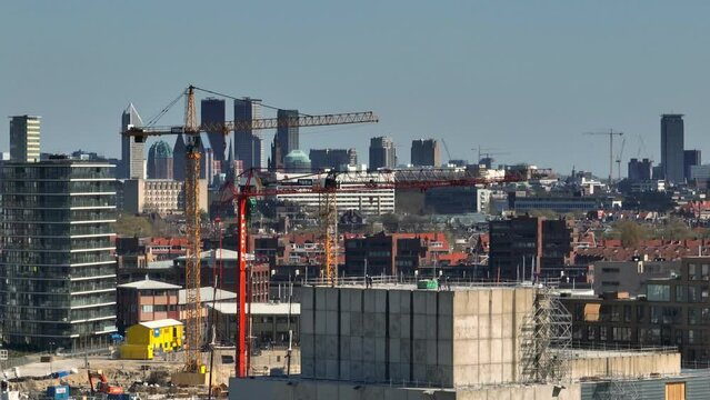 Cranes at Scheveningen construction site with Den Haag skyline in back. Drone
