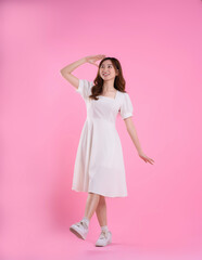 full body image of asian woman in skirt posing on pink background