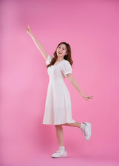 full body image of asian woman in skirt posing on pink background