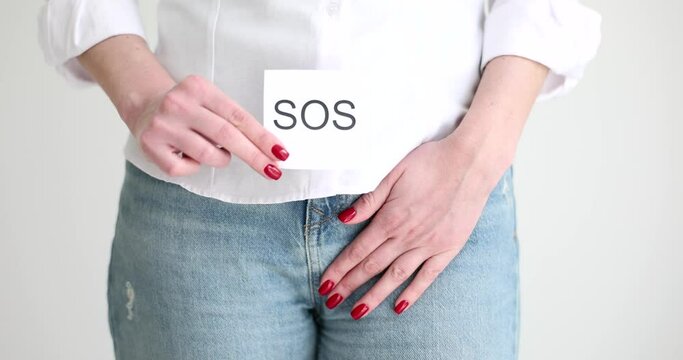 Woman showing sos sign and holding genitals with hand closeup movie slow motion. Treatment of sexually transmitted diseases in women and emergency contraception concept