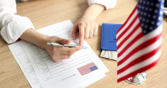Female hands filling out application for american visa at embassy closeup 4k movie slow motion. Obtaining documents for moving to USA concept 