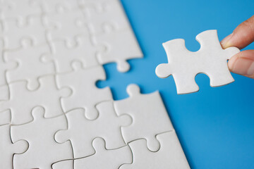 Closeup hand  connecting jigsaw puzzle with sunlight effect, Business solutions, success and strategy concept