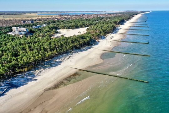 Aerial view looking from the sea over the beach and coastal forest to the village of Rogowo near Kolberg, Poland, with a hotel for vacation
