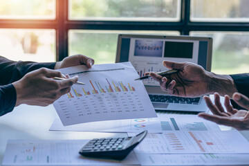Business teams review documents, graphs, charts and financial reports for return on investment or business investment risk analysis, teamwork concepts.