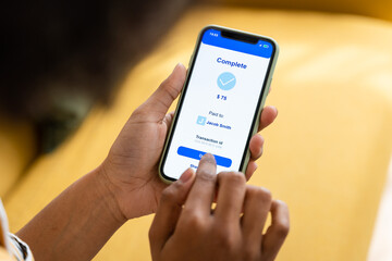 Crop faceless woman using smartphone paying online