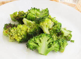 fried inflorescences of broccoli with provencal herbs on white plate