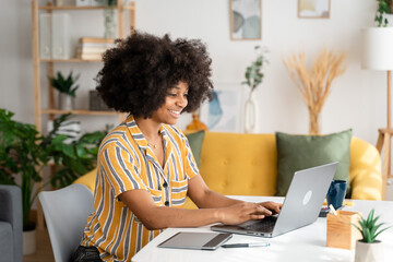 Smiling black woman working on laptop