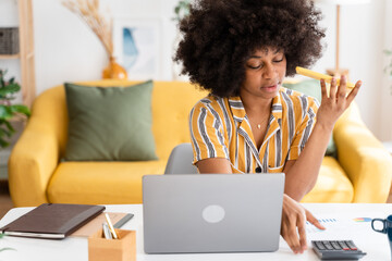 Naklejka na ściany i meble Smiling black woman using laptop at home