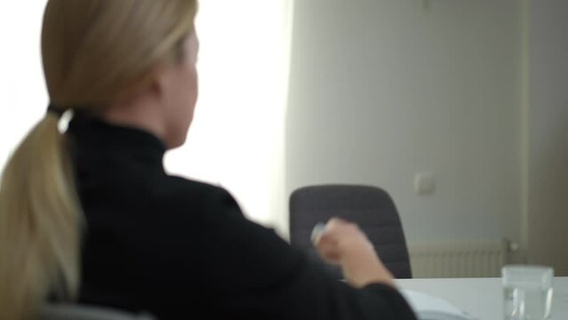 Dissatisfied patient leaving psychologist office walking away indoors. Portrait of unsatisfied Caucasian young woman listening to therapist standing up leaving