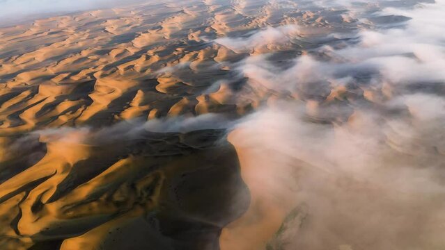 Aerial view titing over endless, Namib desert dunes, foggy morning in Namibia