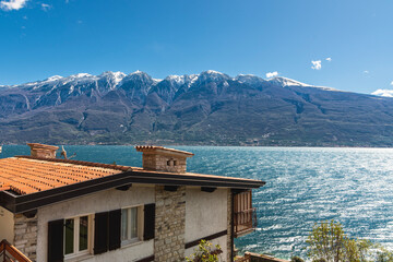 View of house and Garda Lake, snowed Alps, Italy