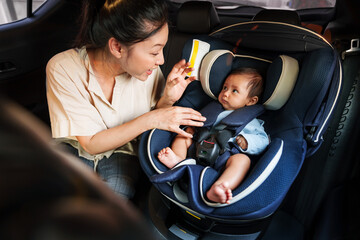 mother take care her newborn baby in car seat. play and talking with child