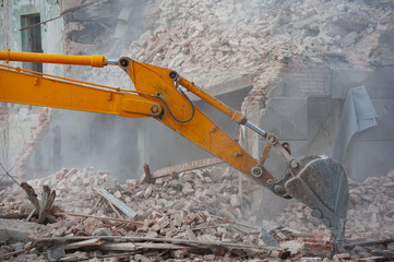 Demolition of building. Excavator breaks old house. Freeing up space for construction of new building