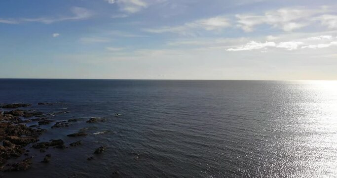 Looking Out To Horizon On Sunny Day Across The English Channel With Aerial Pan Left To Reveal Thurlestone Coastline In South Devon.