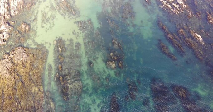 Aerial Birds Eye View Of Low Tide Showing Jurassic Rock Striations With Small Waves Coming In