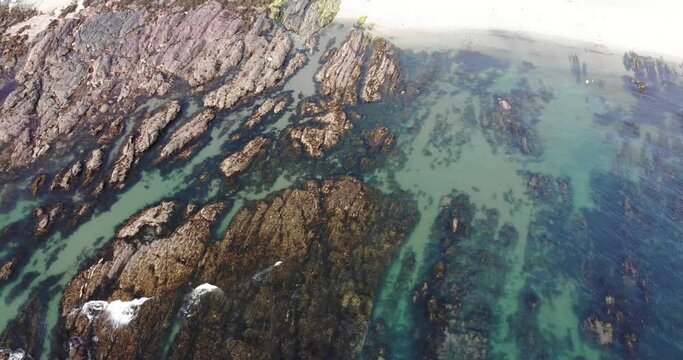 Aerial Birds Eye View Of Low Tide Showing Jurassic Rock Striations. Dolly Right