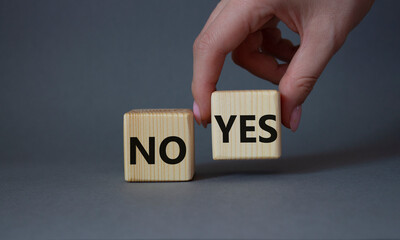 Yes vs No symbol. Businessman hand is making a choice between YES and No symbol. Beautiful grey background. Business concept. Copy space.