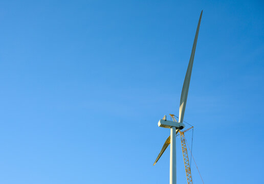Wind turbine under construction against clear sky