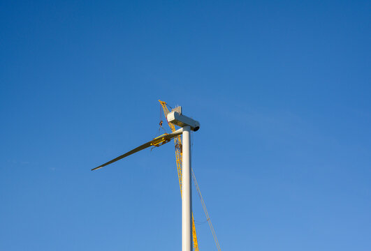 Wind turbine under construction against clear sky