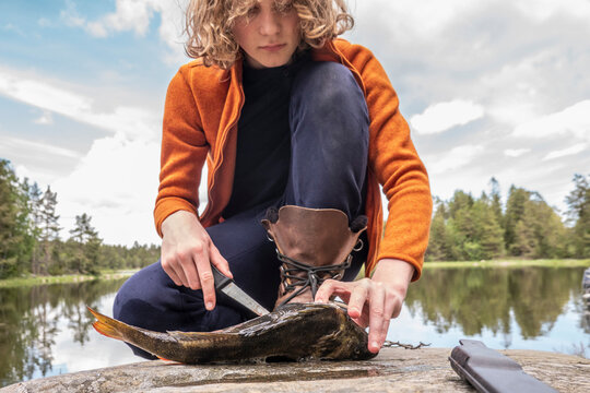 Boy gutting freshly caught fish