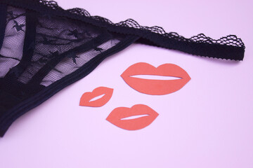 Lace sexy black women's underwear, with red kisses on a light background.
