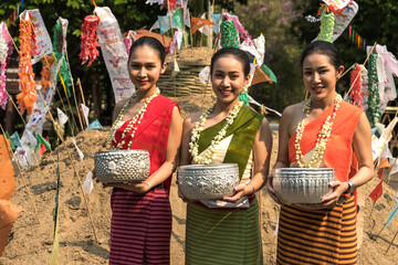 Beautiful Thai women in traditional Northern Thai dress holding water bowl in Chiangmai Water Festival 