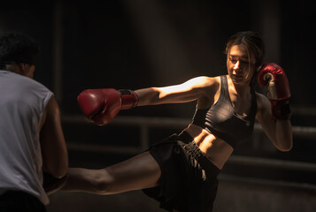 Strong Muay Thai boxer sportswoman doing boxing training with trainer