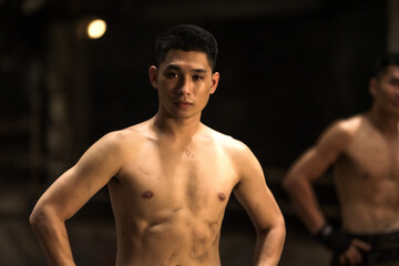 Fototapeta na wymiar Portrait young confident Muay Thai boxers in the dark, Sport Thai Boxing