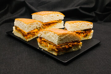 Sandwich with pistasso, cheese, lettuce, and toasted bread. Front view isolated on black background.
