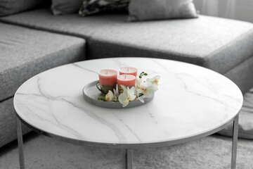 Decorative candles on a concrete base on a marble table in a room. Modern interior in the living...