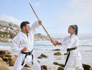 The harder you train, the shorter the fight. Shot of two young martial artists practicing karate...