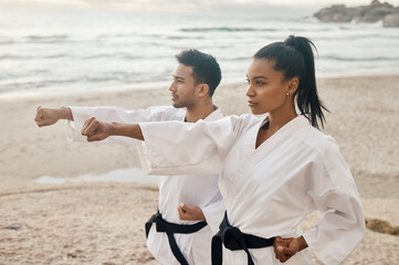 You can only fight the way you practice. Shot of two young martial artists practicing karate on the beach. © Siphosethu Fanti/peopleimages.com