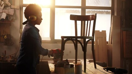 Crafty female carpenter in wood workshop.