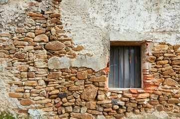 Ancient stone rough facade with window