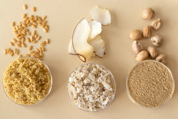 Obraz na płótnie Canvas Gluten-free golden flax, coconut and chickpea flour on beige background, close-up