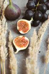 Gold autumn. Croissant, dark grapes, book and figs on the grey table