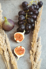 Gold autumn. Croissant, dark grapes, book and figs on the grey table