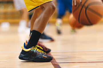 A basketball player bounces a basketball during a training session. Youth basketball team on...