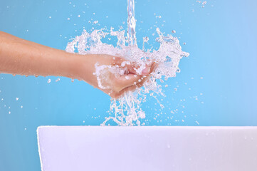 Fototapeta premium Take one to the face. Shot of an unrecognizable woman washing her hands against a blue background.