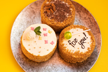 Three bento cakes with different designs on a yellow background.