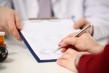 Doctor shows patient tablet with documents in clinic closeup. Signing and concluding medical contract and insurance